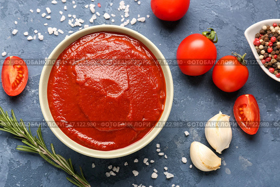 Чаша вкусной томатной пасты, розмарина, перца и зубчиков чеснока на синем фоне гранж. Стоковое фото, фотограф Pixel_shot / Фотобанк Лори