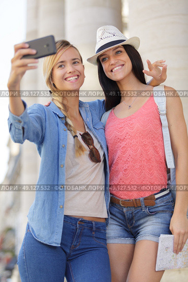 cheerful tourist female friends taking photos of themselves. Стоковое фото, агентство Ingram Publishing / Фотобанк Лори