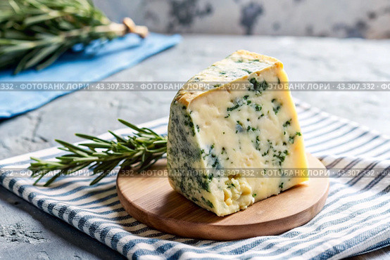Cheese with mold, a slice of cheese with mold door blue or Roquefort on a cutting board. Delicious food. Стоковое AI-изображение, AI-художник Photojuli / Фотобанк Лори