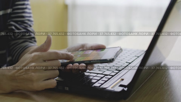 Человек листает ленту с картинками на телефоне сидя за столом. Стоковое видео, видеограф Valeryi Vysotkov / Фотобанк Лори