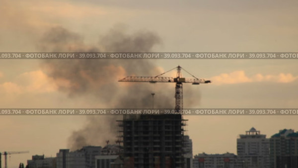 Черный дым клубится над строительной площадкой многоэтажки. Стоковое видео, видеограф Цыбин Вадим / Фотобанк Лори