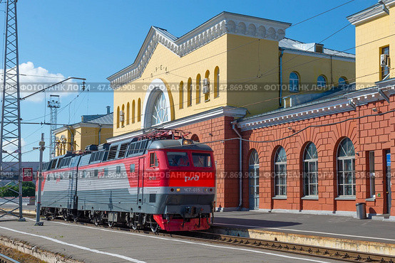 Чешский пассажирский электровоз ЧС7-015 у здания железнодорожного вокзала солнечным июльским днем. Орёл (2021 год). Редакционное фото, фотограф Виктор Карасев / Фотобанк Лори