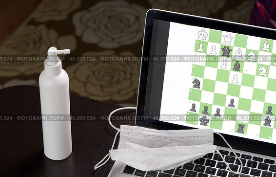 Chess task on laptop screen online. Near antibacterial spray and medical mask. Leisure in self-isolation. International chess day. Стоковое фото, фотограф Vadzim Yakubovich / Фотобанк Лори