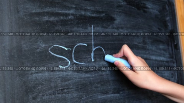 Child Hand Writing Word School on Blackboard. Little Pupil Holds Chalk and Writes on Chalkboard. Стоковое видео, видеограф Марина Демидюк / Фотобанк Лори