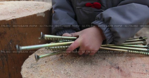 Child holding bunch of steel screws. Стоковое видео, видеограф Ekaterina Demidova / Фотобанк Лори