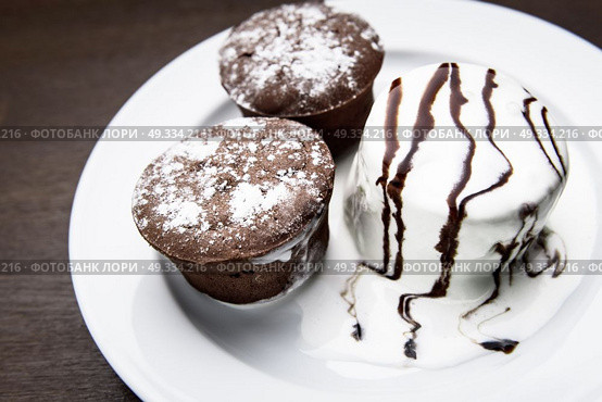 chocolate muffins with ice cream drizzled with chocolate topping. Стоковое фото, агентство Ingram Publishing / Фотобанк Лори