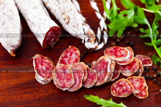 Chopped sausage fuet on wooden table. Стоковое фото, фотограф Яков Филимонов / Фотобанк Лори