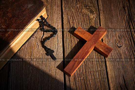 Christian cross on wood bible and rosary beads over wooden vintage background. Стоковое фото, агентство Ingram Publishing / Фотобанк Лори