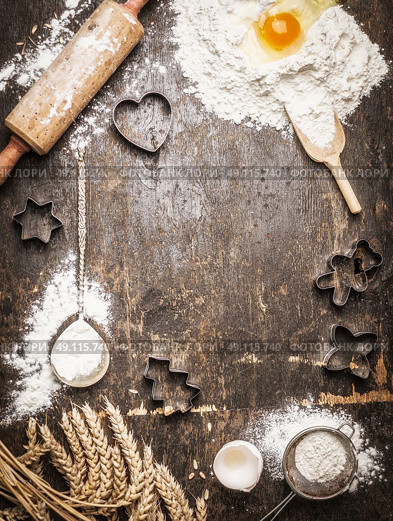 Christmas baking background with ingredients and  tools: Cookie Cutters, Cups, Mats, Rolling Pin, spoon . Dark, rustic, top view, frame. Стоковое фото, агентство Ingram Publishing / Фотобанк Лори