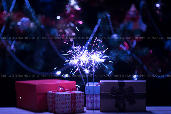Christmas holding bengal burning sparkler light. Стоковое фото, агентство Ingram Publishing / Фотобанк Лори