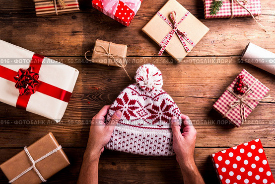 Christmas presents laid on a wooden table background. Christmas presents on a table. Стоковое фото, агентство Ingram Publishing / Фотобанк Лори