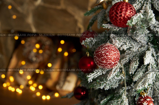 Christmas toys balls hang on fir branch, against backdrop of fireplace. Стоковое фото, фотограф Aleksandra Selivanova / Фотобанк Лори