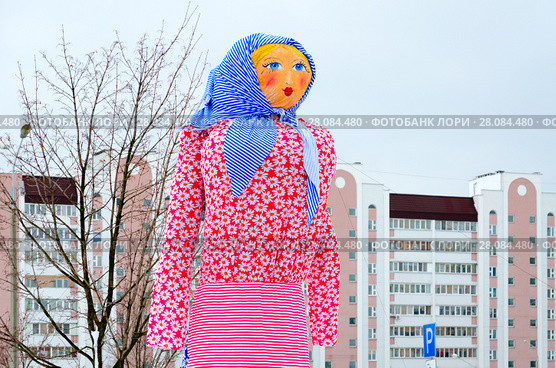 Чучело Масленицы на фоне неба и городского здания, Гомель, Беларусь (2018 год). Стоковое фото, фотограф Ольга Коцюба / Фотобанк Лори