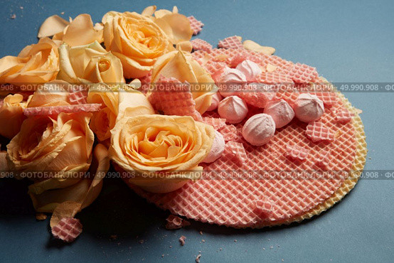 Circle waffles with orange roses. Waffles as decoration of navy blue background. Many roses of orange color represented on waffles.. Waffles as decoration of background. Стоковое фото, агентство Ingram Publishing / Фотобанк Лори