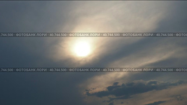 Cirrus clouds cover the disk of the sun with clouds. The disappearance of the sun behind thick dark clouds. Time lapse. Sunbeams in the haze. Sunset for Halloween. Weather forecast. Sky background. Стоковое видео, видеограф Юлия Петровская / Фотобанк Лори