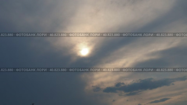 Cirrus clouds cover the disk of the sun with clouds. The disappearance of the sun behind thick dark clouds. Sunbeams in the haze. Sunset for Halloween. Weather forecast. Sky background. Стоковое видео, видеограф Юлия Петровская / Фотобанк Лори