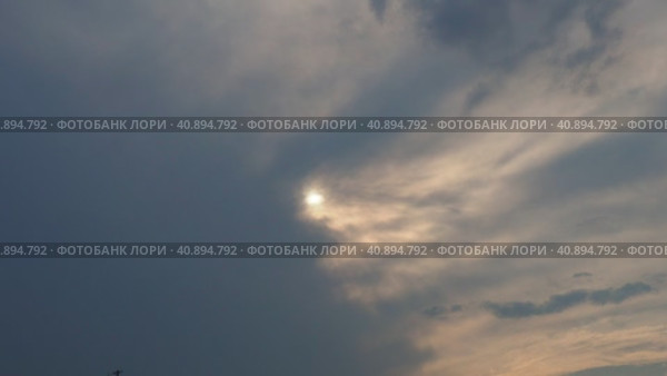 Cirrus clouds cover the disk of the sun with clouds. The disappearance of the sun behind thick dark clouds. Sunbeams in the haze. Sunset for Halloween. Weather forecast. Sky background. Стоковое видео, видеограф Юлия Петровская / Фотобанк Лори