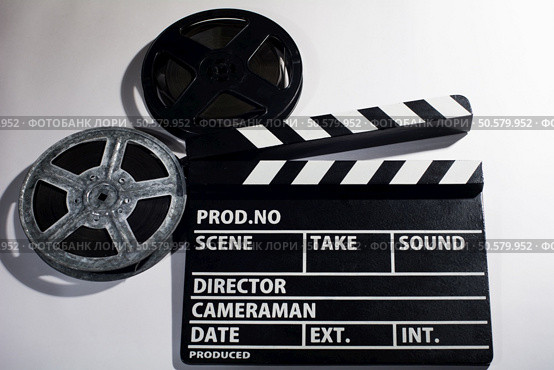 Clap movie on a light background. Metal or plastic film coil. Objects for shooting movies and demonstrations. Clap movie on a light background. Стоковое фото, агентство Ingram Publishing / Фотобанк Лори