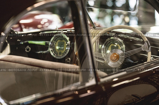 Classic luxury interior of a retro Alfa Romeo car and a close-up steering wheel. Russia, May 11, 2024. Редакционное фото, фотограф Photojuli / Фотобанк Лори