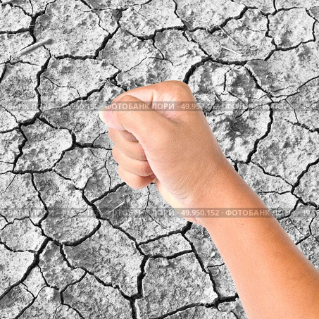 Clenched a fist on dry cracked soil. Стоковое фото, агентство Ingram Publishing / Фотобанк Лори