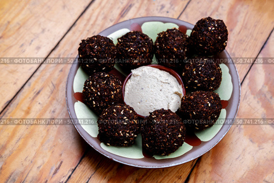 Close up falafel balls with humus on a plate on a wooden background. Стоковое фото, фотограф Алена Аксенова / Фотобанк Лори