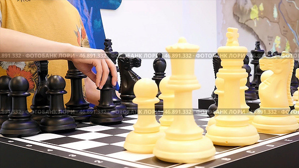 Close up for people playing giant chess, board games concept. Стоковое фото, фотограф David Kashakhi / Фотобанк Лори