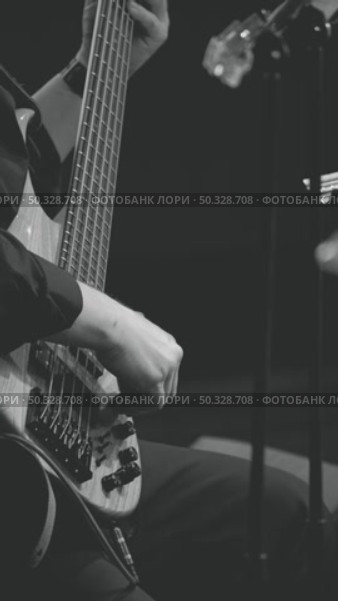 Close-up of a musician's hand, masterfully playing bass guitar, against a dark background. A bass guitarist playing a five-string bass guitar at a concert. Стоковое видео, видеограф Воловодов Владимир / Фотобанк Лори