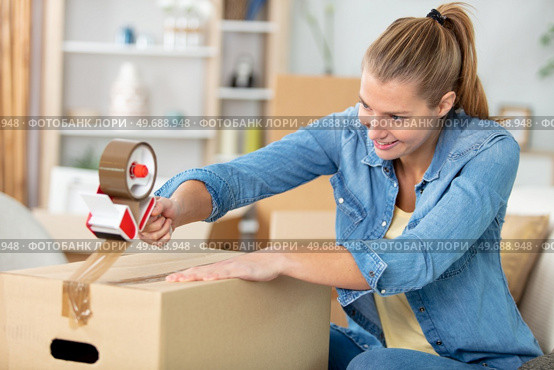 close-up of female sealing cardboard box with adhesive tape. Стоковое фото, агентство Ingram Publishing / Фотобанк Лори