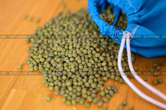 Close up of green mung bean vigna radiata in blue reusable package on wooden background. Eco packaging concept. Стоковое фото, фотограф Ольга Балынская / Фотобанк Лори