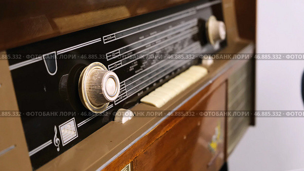 Close-up of man's hand rotating the knob on the old radio. Стоковое фото, фотограф David Kashakhi / Фотобанк Лори
