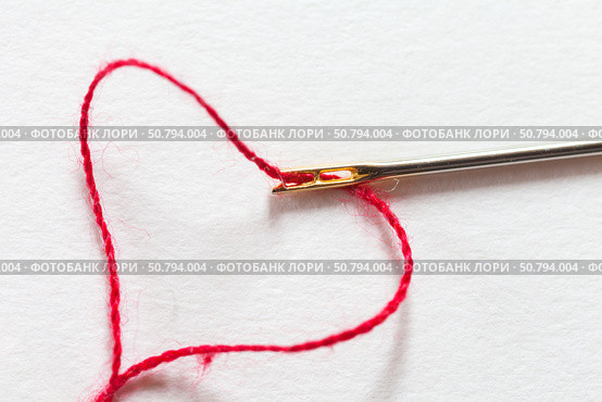 Close-up of metal needle for visually impaired people with special gold plated needle-eye and red thread in heart shape on white background. Top view, copy space, flat lay, macro, mockup. Стоковое фото, фотограф Виктория Катьянова / Фотобанк Лори