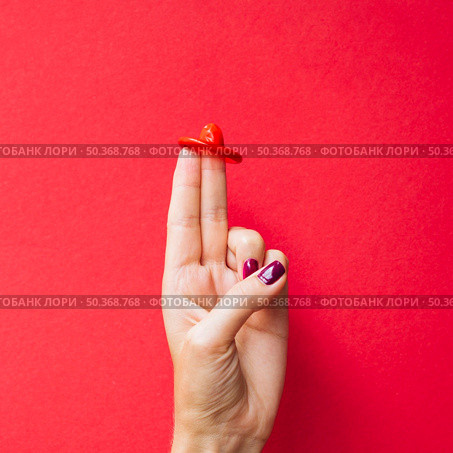 close up red condom woman s fingers. Стоковое фото, агентство Ingram Publishing / Фотобанк Лори