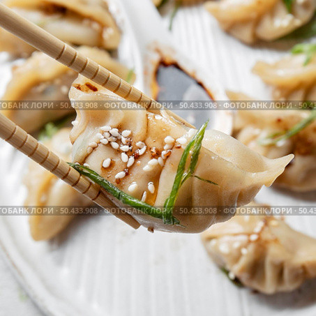 close up sticks holding asian food. Стоковое фото, агентство Ingram Publishing / Фотобанк Лори