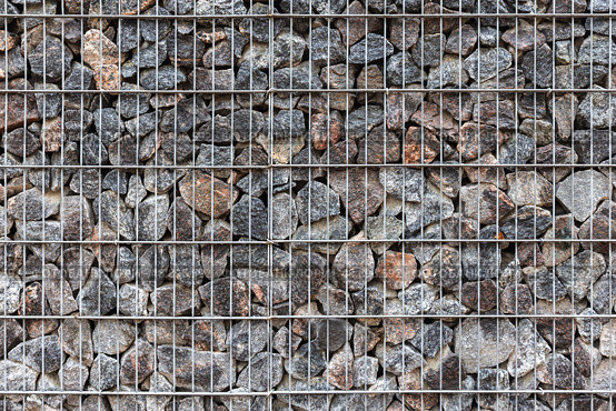 Close-up view of a metal wire fence frame filled with rocks. Gabion. Стоковое фото, фотограф EugeneSergeev / Фотобанк Лори