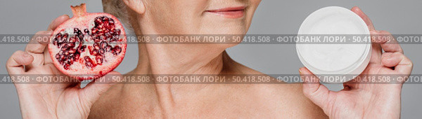 close up woman holding pomegranate cream. Стоковое фото, агентство Ingram Publishing / Фотобанк Лори