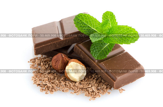 Closeup detail of chocolate parts, hazelnuts and mint leaves on white background. Стоковое фото, агентство Ingram Publishing / Фотобанк Лори