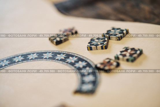 Closeup soft focus of wooden blocks with authentic ornaments of typical taracea of Granada, placed on Spanish flamenco guitar blank in luthier workshop. Wooden blocks with ornaments of taracea, placed on Spanish flamenco guitar in luthier workshop. Стоковое фото, агентство Ingram Publishing / Фотобанк Лори
