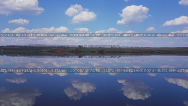 Clouds are reflected in smooth water of lake - timelapse, 4k. Стоковое видео, видеограф Михаил Коханчиков / Фотобанк Лори