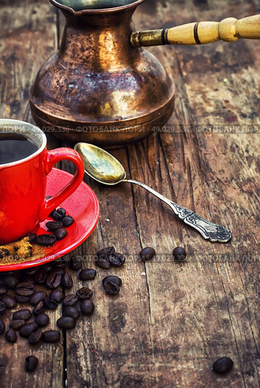 Coffee and cezve. Red coffee Cup and saucer on the background of spilling the beans and cezve. Стоковое фото, агентство Ingram Publishing / Фотобанк Лори