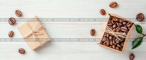 Coffee Beans Gift: Aromatic Present of Roasted Coffee in Eco-Friendly Packaging on White Wooden Background. Стоковое AI-изображение, AI-художник Данила Большаков / Фотобанк Лори