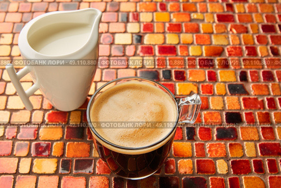 Coffee glass cup with cream on tiles red brown golden table. Стоковое фото, агентство Ingram Publishing / Фотобанк Лори