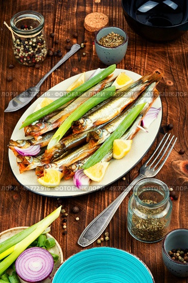 Cold smoked capelin fish. Salty snacks. Omega3.. Smoked capelin fish with lemon. Стоковое фото, агентство Ingram Publishing / Фотобанк Лори