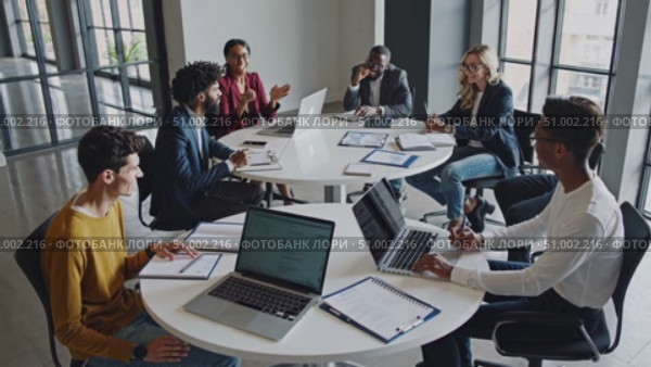 Colleagues collaborating, sharing ideas on laptops during team meeting in contemporary workspace, highlighting professional interaction and workplace communication. Стоковое AI-видео, аниматор Данил Руденко / Фотобанк Лори
