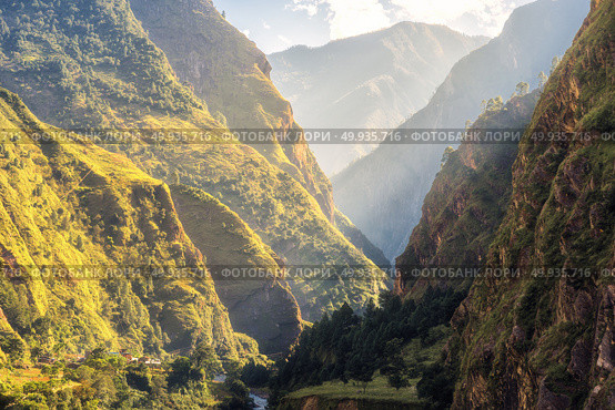 Colorful landscape with high Himalayan mountains, green forest, blue sky with clouds and yellow sunlight at sunrise in summer in Nepal. Mountain valley in the morning. Travel in Himalayas. Nature. Colorful landscape with mountains, river at sunrise in summer. Стоковое фото, агентство Ingram Publishing / Фотобанк Лори