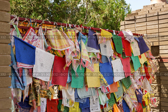 Colorful prayer flags hang on the gates of the Buddhist temple Golden Abode of Buddha Shakyamuni, Elista, Kalmykia, Russia, July 4, 2025. Редакционное фото, фотограф Екатерина Топорова / Фотобанк Лори