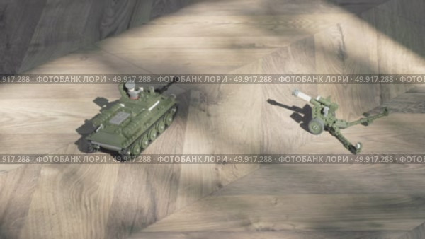 Colorful Toy Tanks and Artillery Arranged on a Wooden Floor in a Creative Display. Стоковое видео, видеограф Olesia Kondrateva / Фотобанк Лори