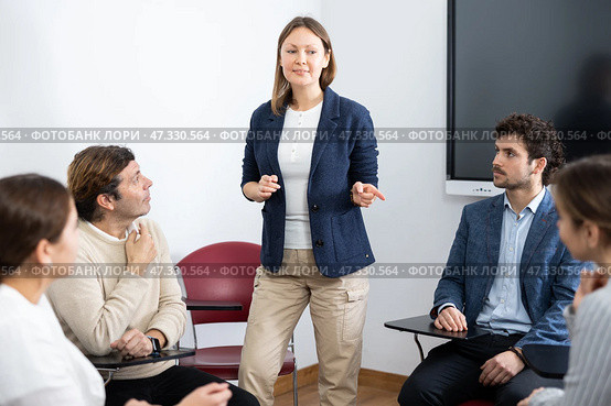Competent female tutor teaching students in college classroom. Стоковое фото, фотограф Яков Филимонов / Фотобанк Лори