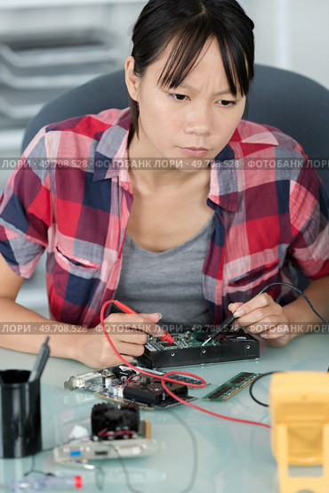 computer technician using multimeter to test hard drive. Стоковое фото, агентство Ingram Publishing / Фотобанк Лори
