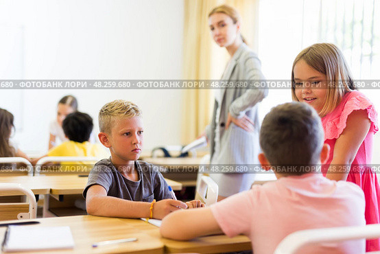 Concentrated preteen girls and boys solving teacher assignments in groups. Стоковое фото, фотограф Яков Филимонов / Фотобанк Лори