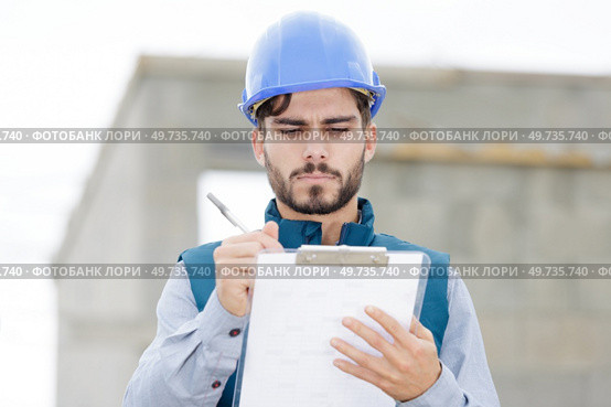 concentrated worker holding a clipboard outdoors. Стоковое фото, агентство Ingram Publishing / Фотобанк Лори